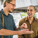 "two men smiling with each other"