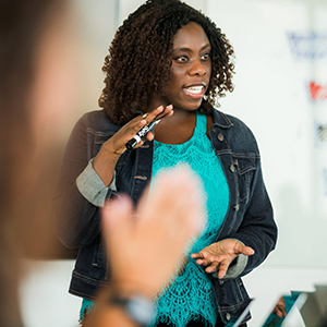 "team meeting with woman presenting to group"