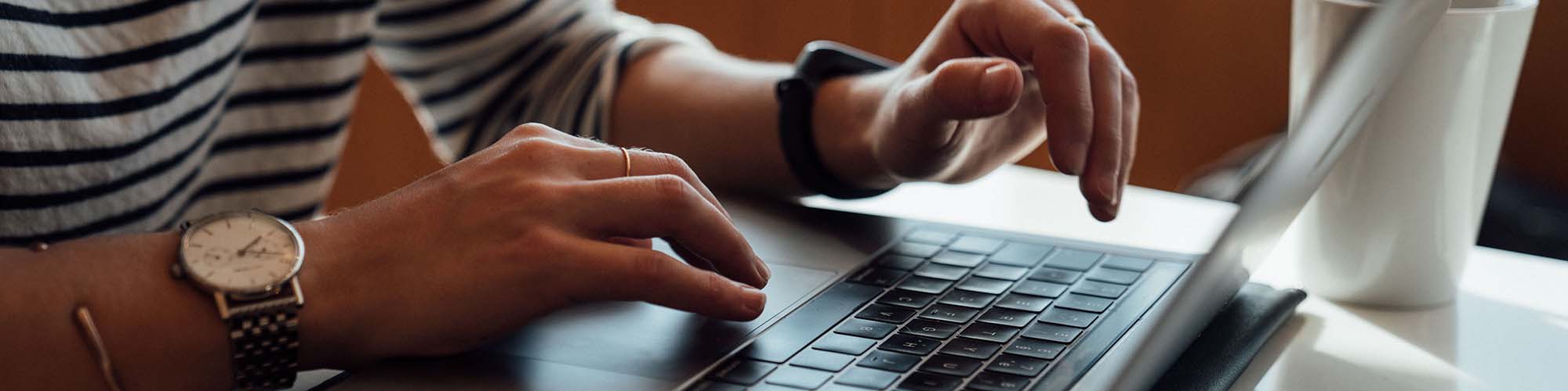 Close up photo of person using a laptop computer.